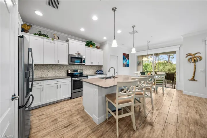 Contemporary kitchen featuring white cabinetry, stone countertops, and stainless steel appliances