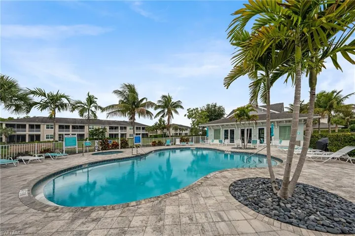 Resort-style pool area featuring an irregularly shaped pool, integrated spa, and surrounding paver decking