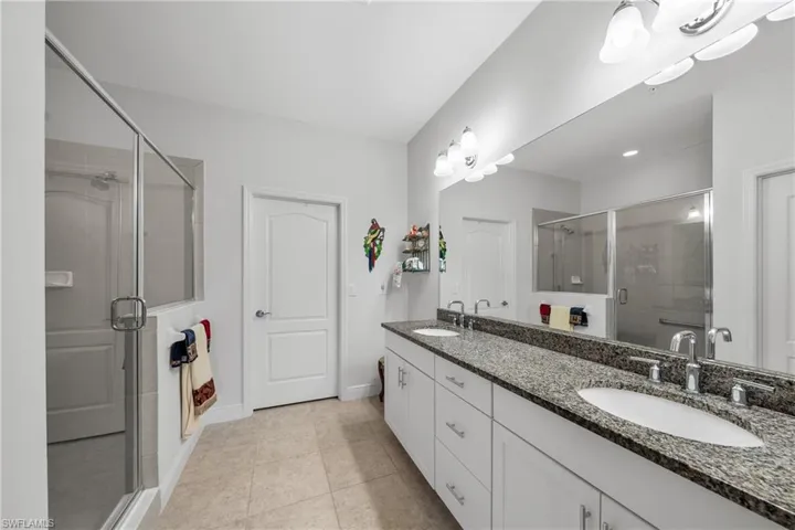 Double vanity with granite countertop, dual undermount sinks, and chrome faucets