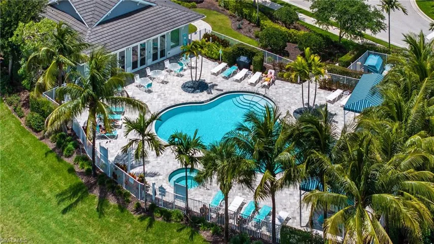 Resort-style pool area featuring a freeform swimming pool, integrated spa, and extensive paver decking