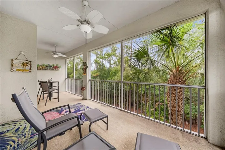 Screened balcony featuring concrete flooring, multiple ceiling fans, and a metal railing system