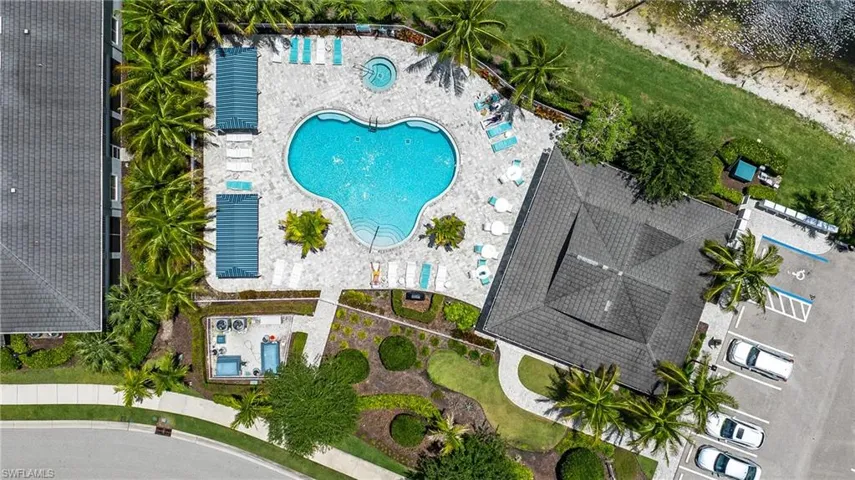 Resort-style pool area featuring a freeform swimming pool, integrated spa, and extensive paver decking