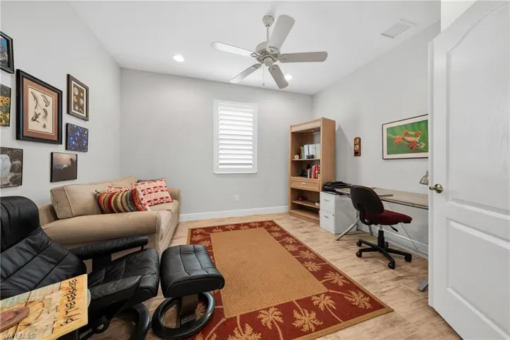 Interior room featuring wood-finish flooring, a ceiling fan with integrated lighting, and recessed ceiling lights