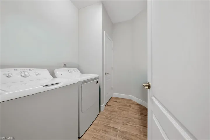 Dedicated laundry area featuring wood-finish tile flooring, a white washer, and a white dryer