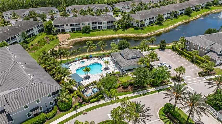 Aerial perspective showcasing a community pool with an integrated spa, surrounded by lounge seating and shaded areas