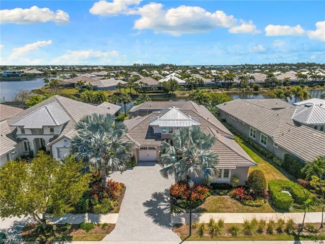 Aerial view of a single-story residence featuring a tiled roof and a paver driveway