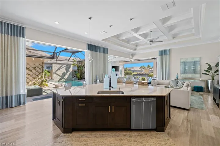 Kitchen island featuring dark wood cabinetry, a light-toned countertop, and integrated sink