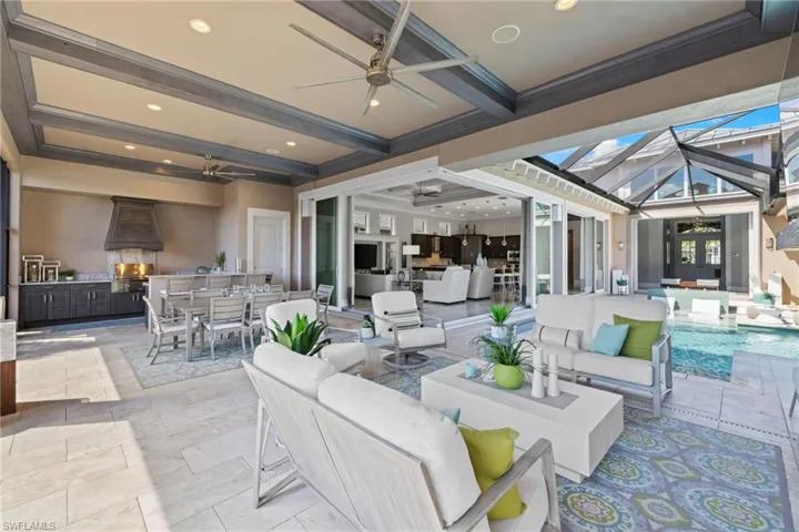 Expansive outdoor living area featuring a covered patio with recessed lighting and ceiling fans