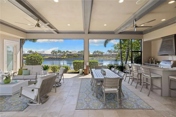 Expansive covered patio featuring a full outdoor kitchen with a built-in grill and a large island with bar seating