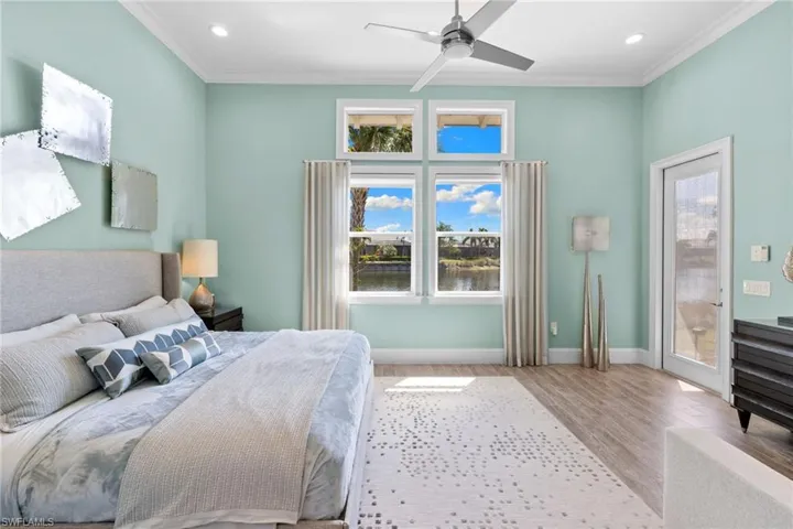 Bedroom #3 (detached casita) featuring multiple windows and a glass-paneled door opening to waterfront scenery