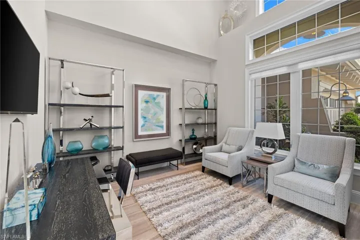 Double-height ceilings complement extensive window treatments, including upper transom windows and lower grid-patterned windows