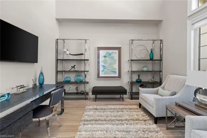 Versatile bonus room featuring wood-finish flooring, high ceilings, and a built-in recessed wall niche
