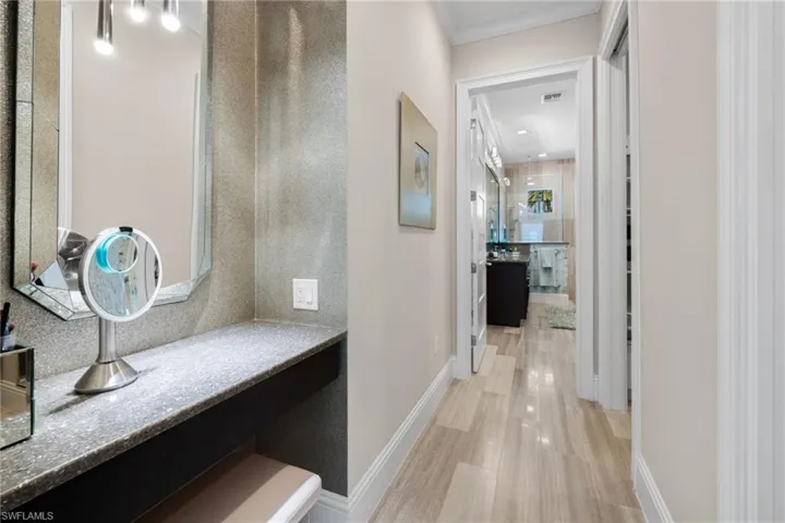 Primary bedroom #1, featuring integrated vanity with a speckled countertop, framed mirror, and chrome vanity lighting