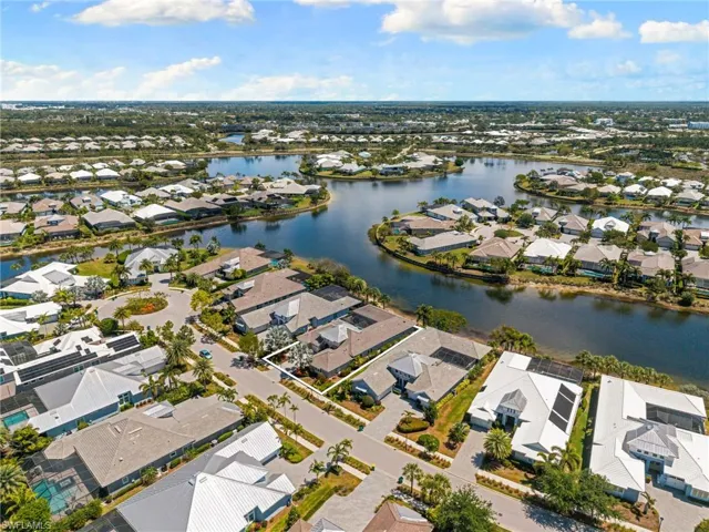 Aerial view showcasing a residential community with numerous properties bordering a winding waterway