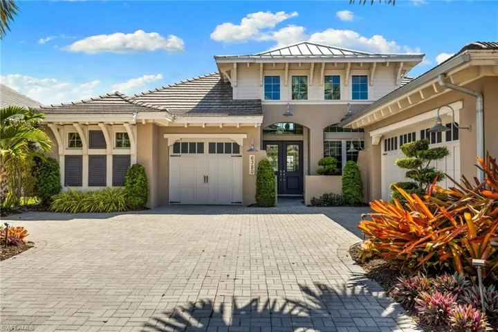 Exterior featuring a neutral stucco finish, tile roofing, and a paver driveway