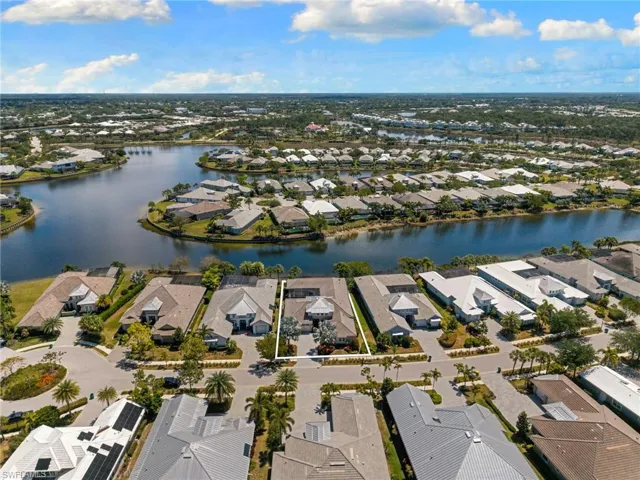 Waterfront community featuring properties with light-toned roofing and mature landscaping