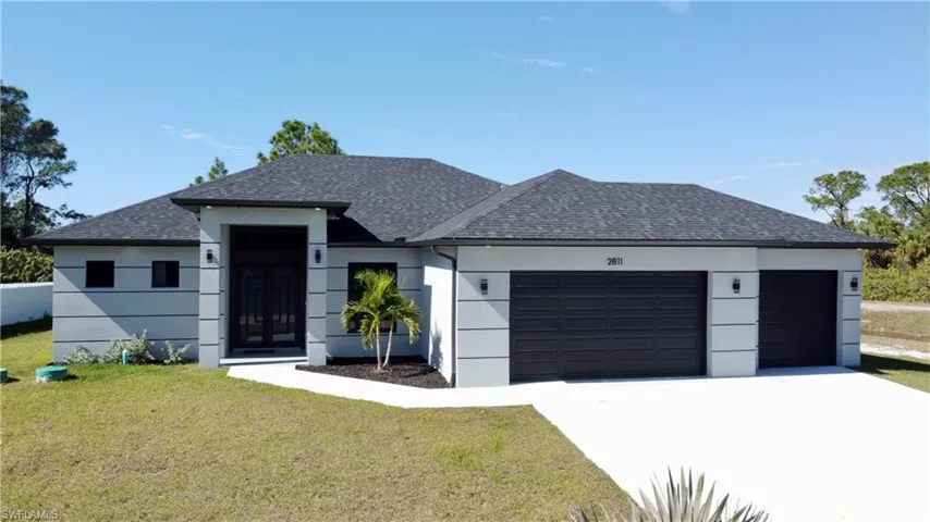 View of front of property featuring a garage and a front yard
