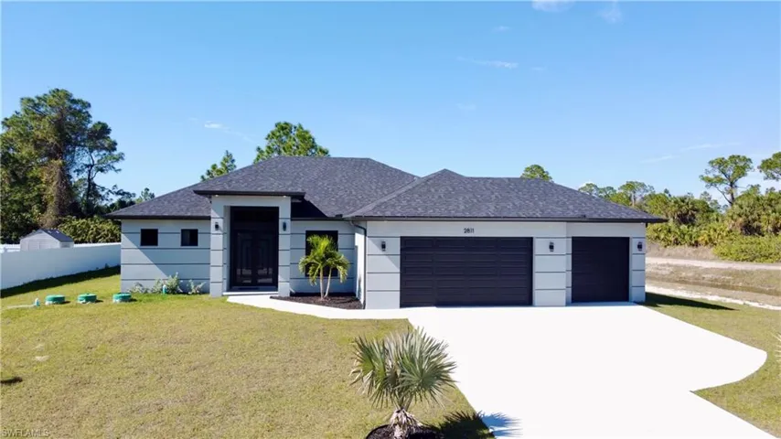 View of front of property featuring a 3 car garage and a front lawn (no ditch)