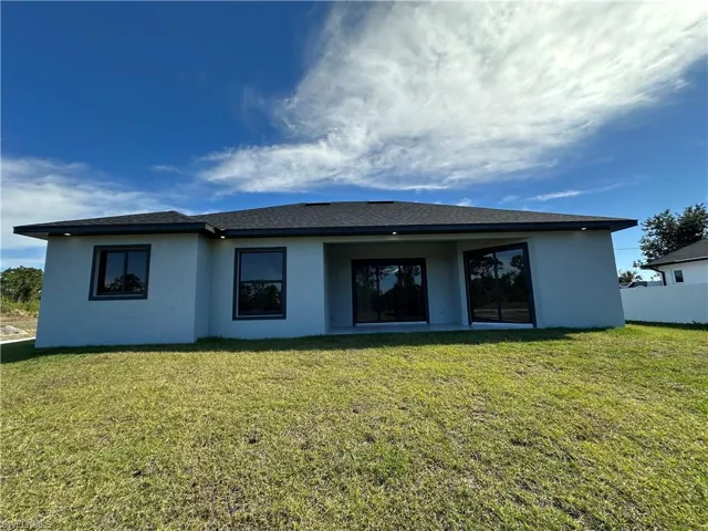 Rear view of house featuring a yard