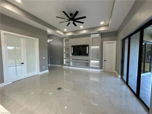 living room with a trey ceiling, french doors, and ceiling fan