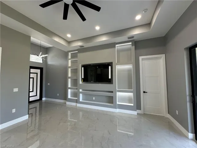 Lliving room featuring built in Media wall and ceiling fan