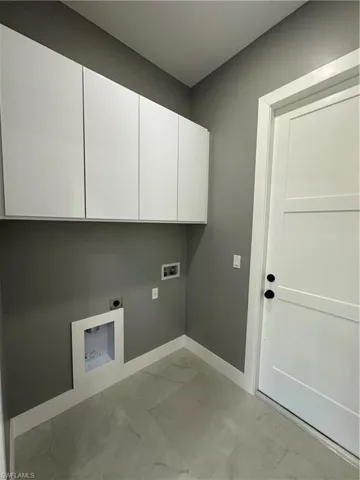 Clothes washing area featuring washer hookup, cabinets, and hookup for an electric dryer