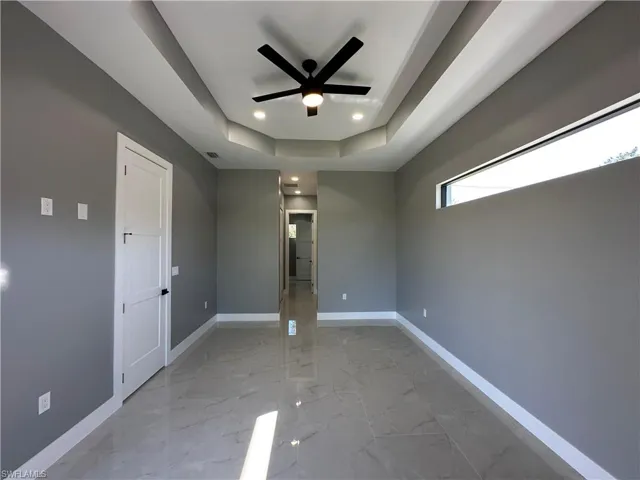 Empty room with a raised ceiling and ceiling fan
