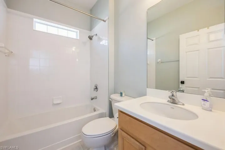Full bathroom with shower / bath combination, toilet, and vanity with extensive cabinet space