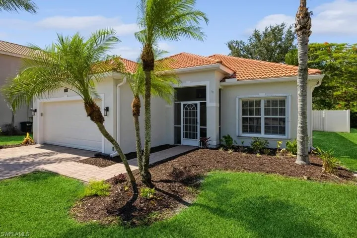 Mediterranean / spanish-style house with a garage and a front lawn
