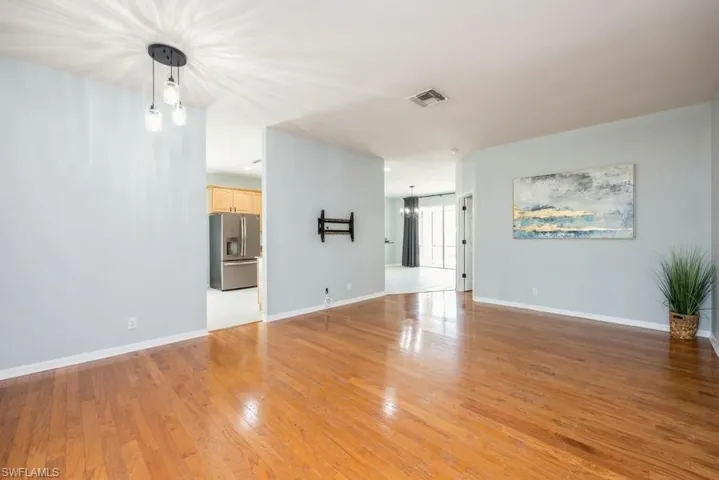 Unfurnished living room featuring a notable chandelier and light hardwood / wood-style flooring