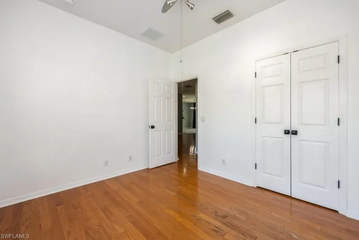 Unfurnished bedroom with wood-type flooring, a closet, and ceiling fan
