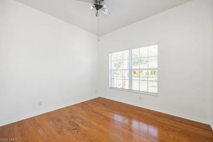 Unfurnished room featuring hardwood / wood-style flooring, ceiling fan, and vaulted ceiling