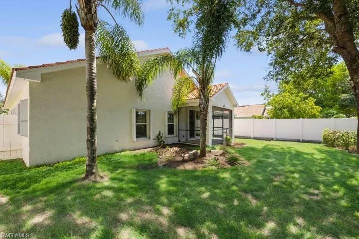 Back of house with a lawn