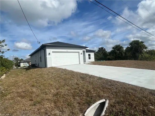 View of home's exterior with driveway, an attached garage, a yard, and stucco siding