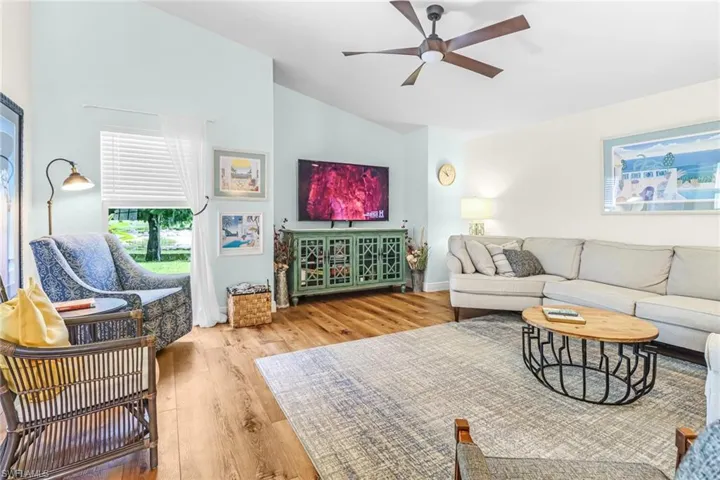 Living room featuring light hardwood / wood-style floors, high vaulted ceiling, and ceiling fan