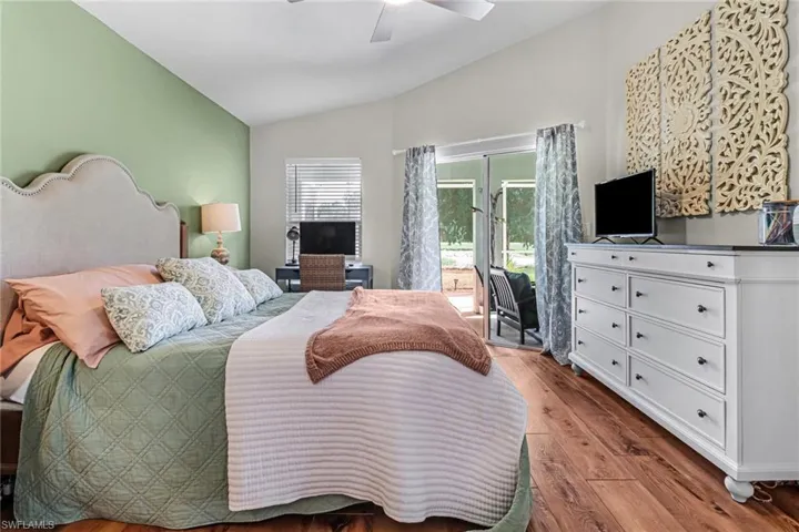 Bedroom featuring vaulted ceiling, ceiling fan, hardwood / wood-style flooring, and access to outside