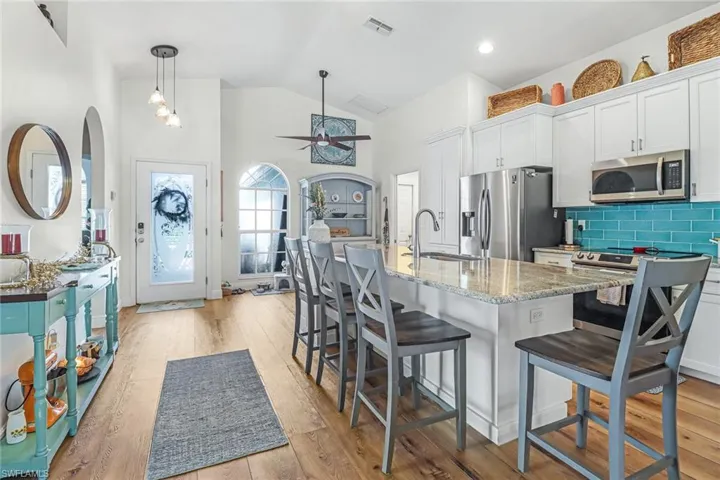 Remodeled open concept kitchen with upgraded cabinets, countertops, and high vaulted ceiling.
