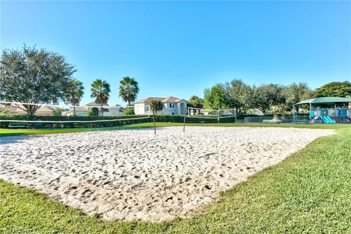Surrounding community with a playground, a lawn, and volleyball court