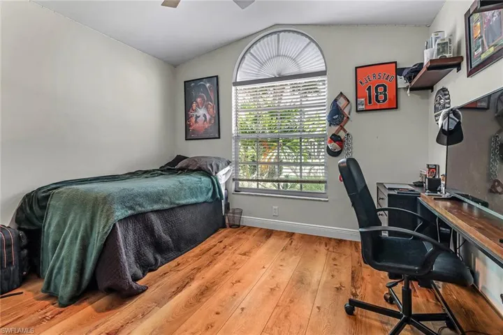 Bedroom featuring ceiling fan, hardwood / wood-style floors, and lofted ceiling