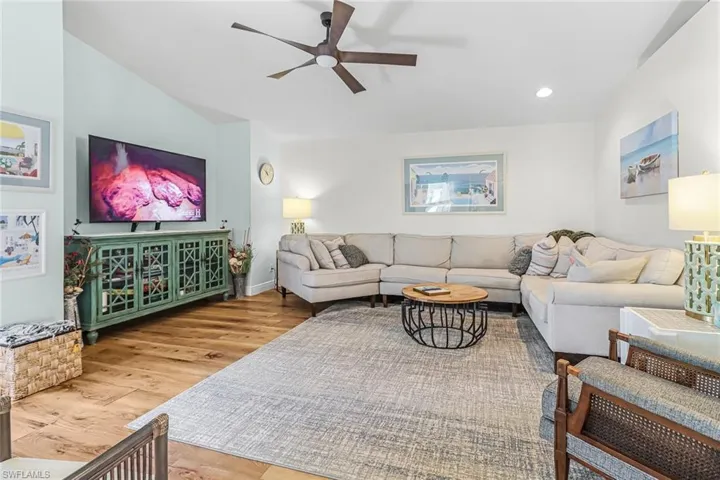 Living room featuring ceiling fan, vaulted ceiling, and hardwood / wood-style floors