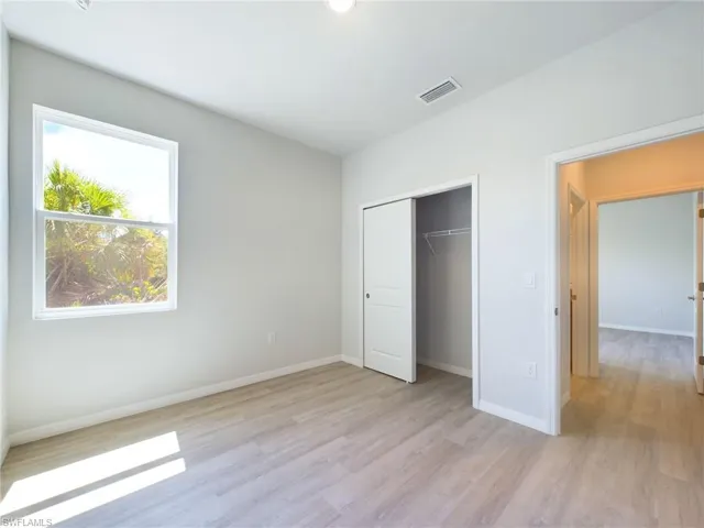 Unfurnished bedroom featuring light wood-type flooring and a closet