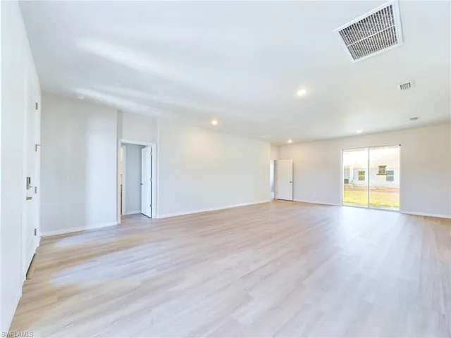 Empty room with light hardwood / wood-style flooring