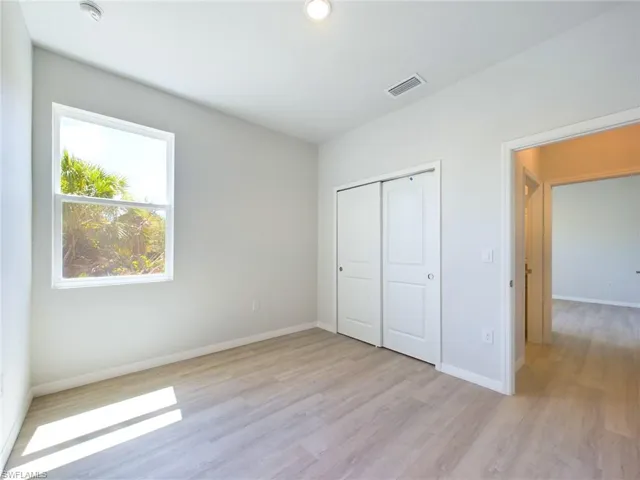 Unfurnished bedroom with a closet and light hardwood / wood-style floors