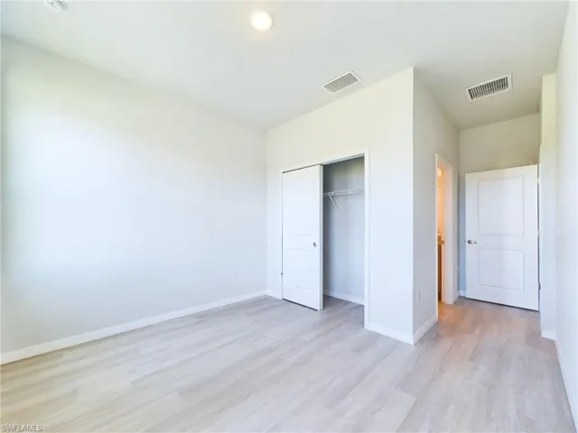 Unfurnished bedroom with light wood-type flooring and a closet