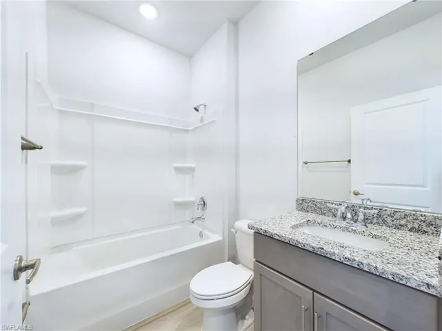 Full bathroom featuring toilet, shower / washtub combination, and vanity