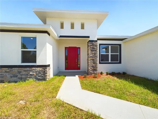 View of exterior entry with a lawn