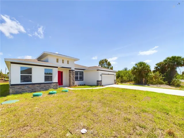 View of front of house featuring a garage and a front yard