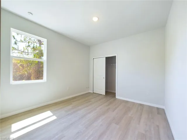 Unfurnished bedroom featuring light hardwood / wood-style flooring and a closet