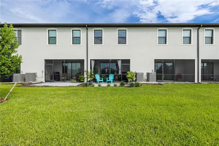 Back of house with a yard, central AC unit, and a patio