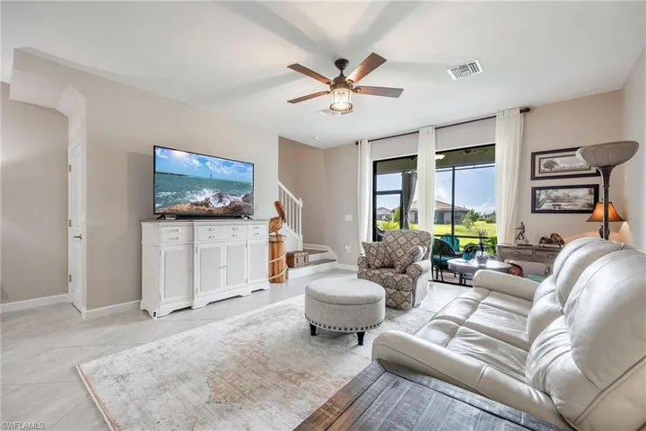 Tiled living room featuring ceiling fan
